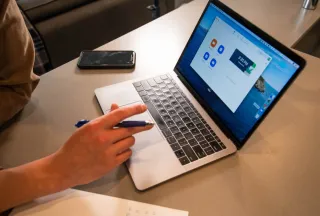 A person using a laptop at a work table