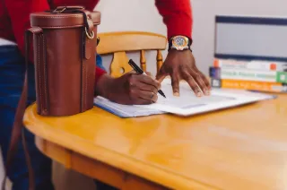 A professional writing in a notebook