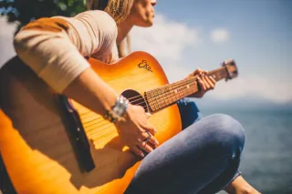 A person playing an acoustic guitar