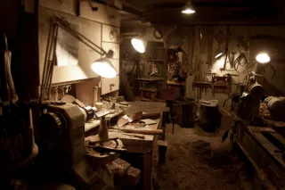 Lathes, hand tools and workbenches arranged inside a woodworking workshop.