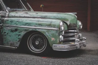 A weathered vintage car parked outdoors